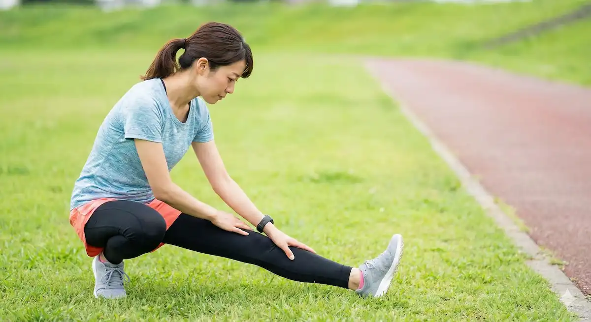 ランニング後にストレッチで体をケアする日本人女性